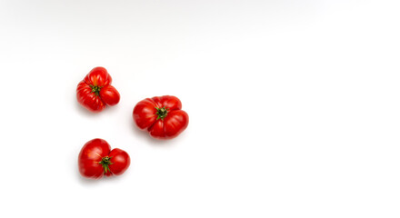 Three unusual tomatoes on a white background. Ugly vegetables.