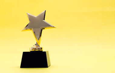 Golden star trophy on yellow background