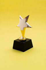 Golden star trophy on yellow background
