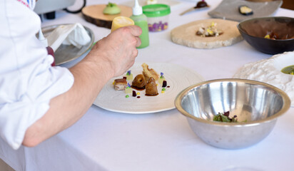 Elaboration of suckling pig dish, almonds with wild flowers and foie. amazing dish. Typical Spanish cosine.