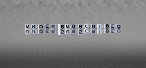 undersubscribed word or concept represented by black and white letter cubes on a grey horizon background stretching to infinity