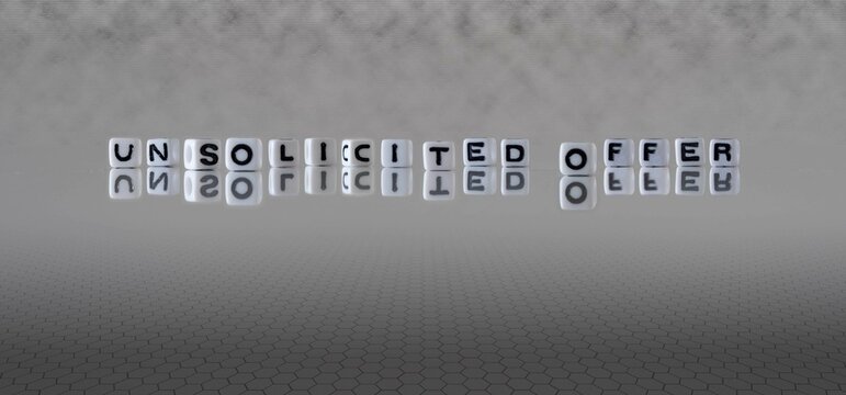 unsolicited offer word or concept represented by black and white letter cubes on a grey horizon background stretching to infinity
