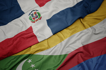 waving colorful flag of comoros and national flag of dominican republic.
