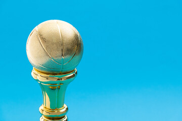 Golden basketball trophy on blue background
