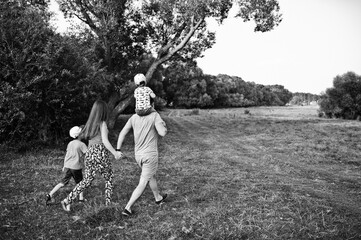 Happy young family: mother, father, two children son on nature having fun.