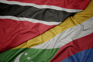 waving colorful flag of comoros and national flag of trinidad and tobago.