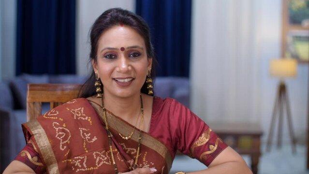 A middle-aged Indian housewife posing for the camera - dressed in traditional dress  conservative female  Indian mother. An attractive Gujarati lady in a traditional Saree smiling and posing - Indi...