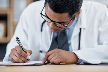 Doctor writing a prescription, survey or medical care paperwork for a patient at the hospital. A...