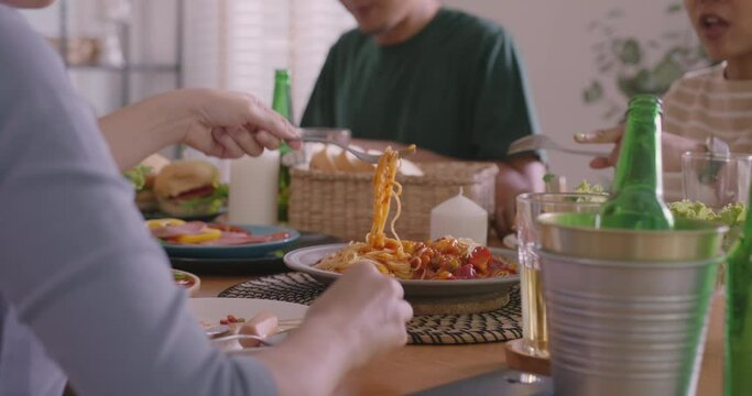 Happy hour good warm time relax diner meal at home. Group of asia people young adult friend man and woman sit at dining table joy fun talk hug cuddle or eat food and drink beer alcohol bottle glass.