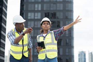Group of African American engineer working at construction site. Male engineer and woman engineer...