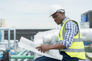 African American male engineer working with building blueprint for checks or maintenance sewer...