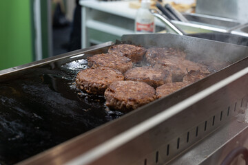 Burgers Well Toasted and Flipped on Both Sides that are Completing their Cooking on a Hot Griddle