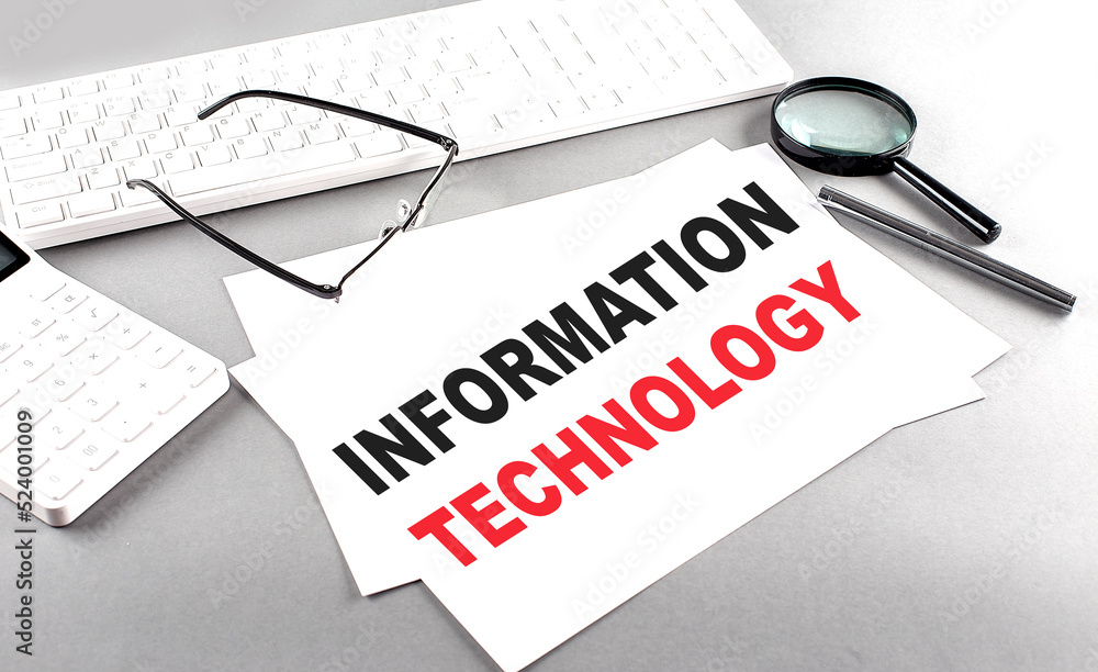 Poster information technology text on a paper on a gray background near a calculator and a white keyboard