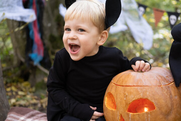 happy boy kid in halloween costume having fun in halloween decorations outdoor