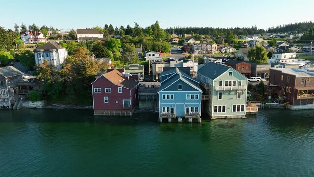 Panning aerial shot of Coupeville's historic business district with multiple buildings hanging out over the water.
