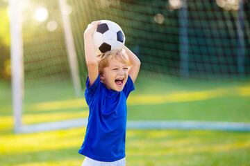 Kids play football. Child at soccer field. © famveldman
