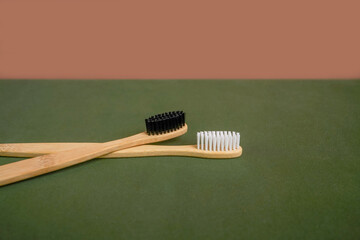 Natural bamboo toothbrush on green beige background.