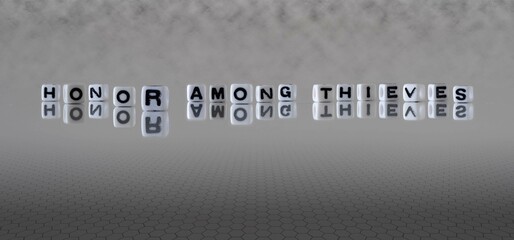 honor among thieves word or concept represented by black and white letter cubes on a grey horizon...