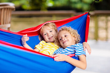 Fototapeta na wymiar Boy in hammock. Kids play in summer garden.
