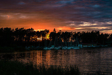 Fototapeta premium Sunset over the lake with the boats in the Czech Republic