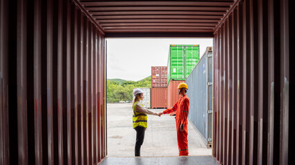 Warehouse business. foreman and CEO Manager woman in safety suit shake hands and conclude a job for transport and logistics after Successfully completed business logistics transportation service