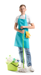 Smiling young man with cleaning supplies on white background