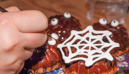 Baker decorating Halloween Cookies. Glazing cookies.