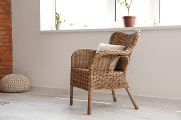 Rattan armchair with cushion near window