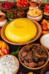 Homemade Romanian Food with polenta, meat, cheese and vegetables. Delicious corn porridge in clay dishes. Mamaliga or polenta, a traditional dish in Moldova, Hungary and Ukrainian cuisine.

