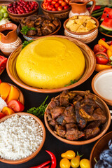 Homemade Romanian Food with polenta, meat, cheese and vegetables. Delicious corn porridge in clay dishes. Mamaliga or polenta, a traditional dish in Moldova, Hungary and Ukrainian cuisine.
