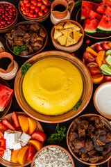 Homemade Romanian Food with polenta, meat, cheese and vegetables. Delicious corn porridge in clay dishes. Mamaliga or polenta, a traditional dish in Moldova, Hungary and Ukrainian cuisine.
