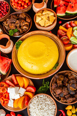 Homemade Romanian Food with polenta, meat, cheese and vegetables. Delicious corn porridge in clay dishes. Mamaliga or polenta, a traditional dish in Moldova, Hungary and Ukrainian cuisine.
