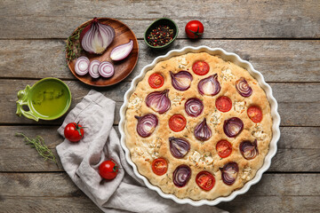 Composition with tasty Italian focaccia and ingredients on wooden background
