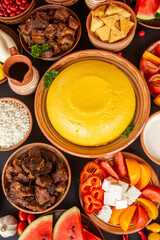 Homemade Romanian Food with polenta, meat, cheese and vegetables. Delicious corn porridge in clay dishes. Mamaliga or polenta, a traditional dish in Moldova, Hungary and Ukrainian cuisine.
