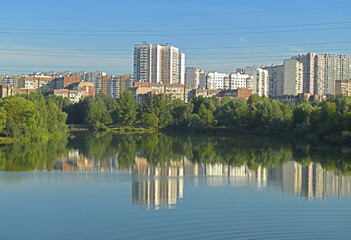 Fototapeta premium Reflection of houses and buildings in Penyaginsky lake in Mitino Landscape Park. Moscow, Russia