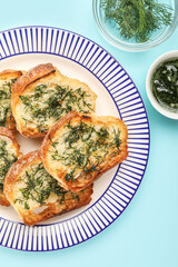 Plate with slices of toasted garlic bread on color background, closeup
