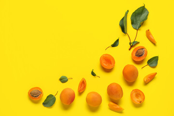 Composition with ripe apricots and leaves on color background