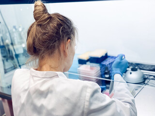 A female PhD student carrying out a cytotoxicity assessment of a new drug molecule using an MTT...