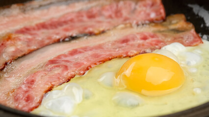 Frying fried eggs with Bacon in hot pan. Family Breakfast concept