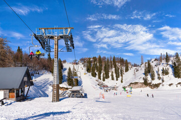 People skiing in Vogel, Slovenia. Sunny weather in the mountains on a perfect ski slope. Slopes in...