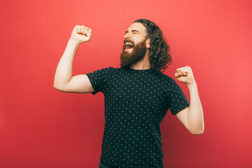 A bearded man cheerfuly is dancing in front of camera