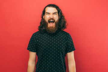 A photo of a young man screaming at the camera because he is angry