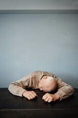 Obraz premium Exhausted senior man sleeping on a table