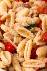 Deliziosi malloreddus con salsa di tonno, pomodorini e basilico, cibo italiano 