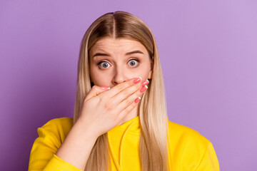 Photo of young girl cover mouth hand oops problem tell secret information isolated over violet...
