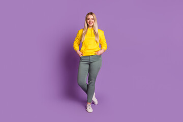 Fototapeta na wymiar Full length photo of young cheerful woman confident standing arms in pocket isolated over violet color background