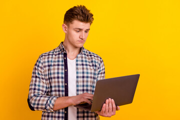 Photo of young man agent type chat laptop project economist banker isolated over yellow color background