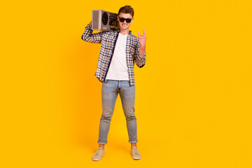 Full length photo of young man hold boombox music disco party retro isolated over yellow color background