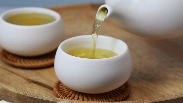 Pouring green tea Oolong in a cup. Healthy chinese tea rich in antioxidants