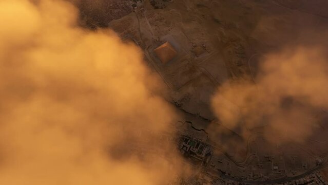 Aerial view flying over the clouds at sunset of the Pyramids of Giza. Cairo, Egypt